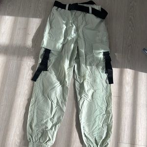 Pants the color green with a black belt around it